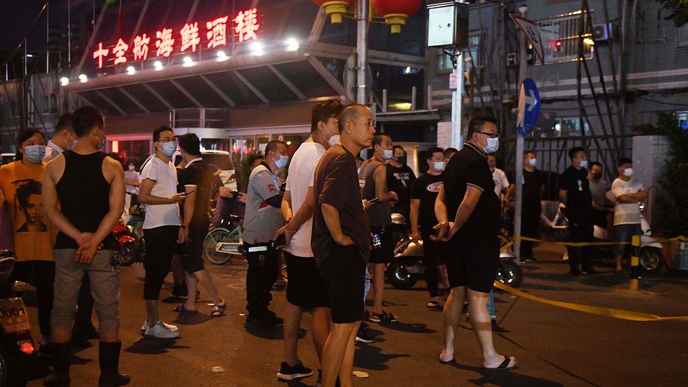 Folksamling utanför köttmarknaden Xinfadi i Peking som har stängts på grund av infektionsrisk.