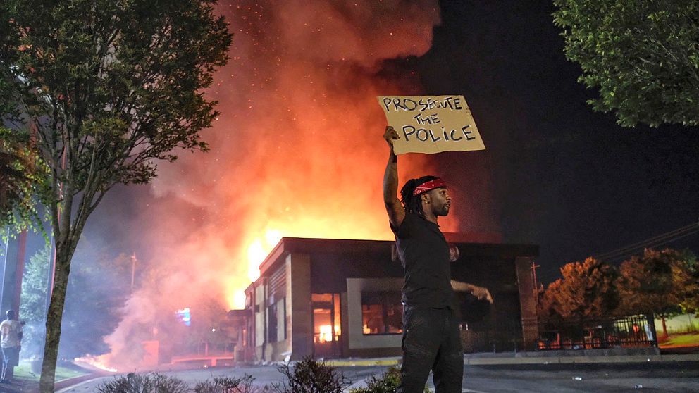 Demonstranter har tänt eld på snabbmatsrestaurangen vid vilken en svart man sköts till döds av polis i Atlanta under fredagen