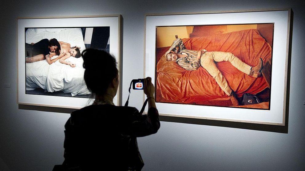 En besökare på Fotografiska Museet fotograferar en utställning med Annie Leibovitz.