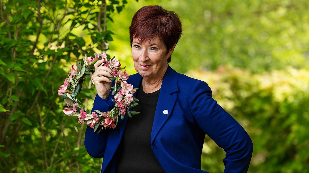 Mona Sahlin är tisdagens sommarvärld i Sommar i P1 på Sveriges Radio. Här står hon i sommargrönska och håller en blomsterkrans.