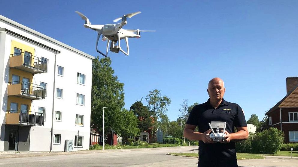 Ljusdals kommuns räddningschef Peter Nystedt har en handkontroll i händerna och en drönare flygandes bredvid sig.