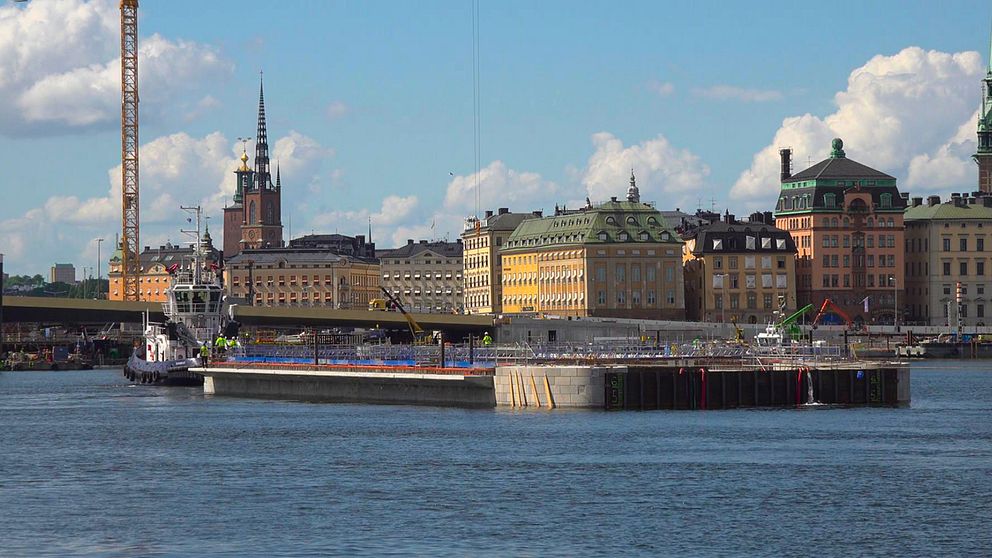 Stor båt glider in mot nya Slussenbygget. I bakgrunden skymtar Gamla Stans äldre byggnader.