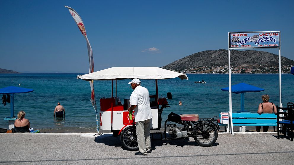 En glassförsäljare i väntan på kunder på ön Salamina strax väster om Aten på måndagen.