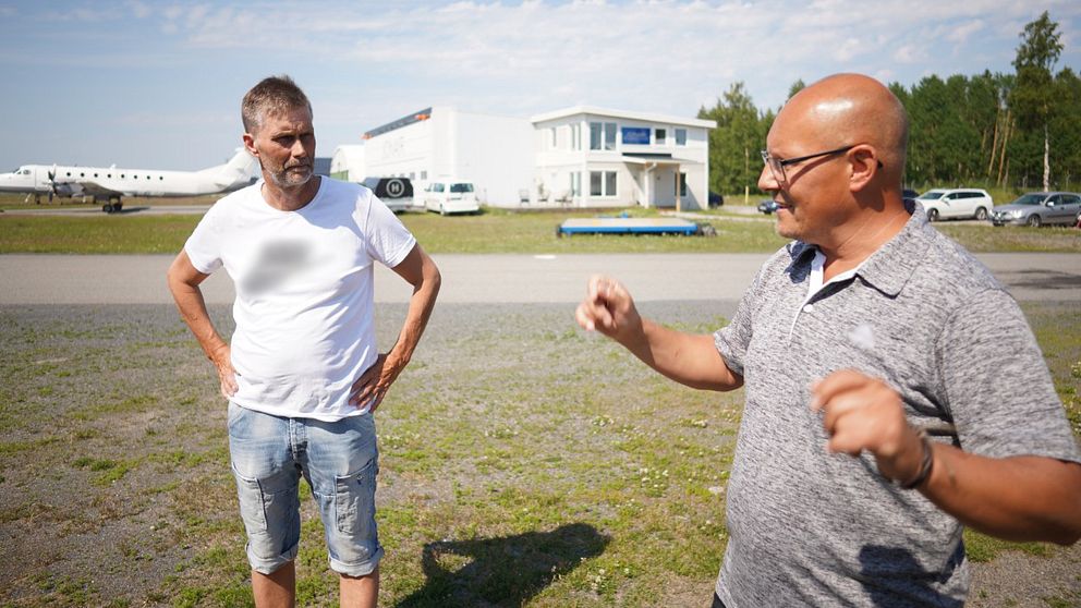 två män står och pratar ute på flygfältet i Umeå