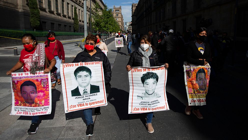 Föräldrar till försvunna studenter håller upp plakat med bilder på sina barn
