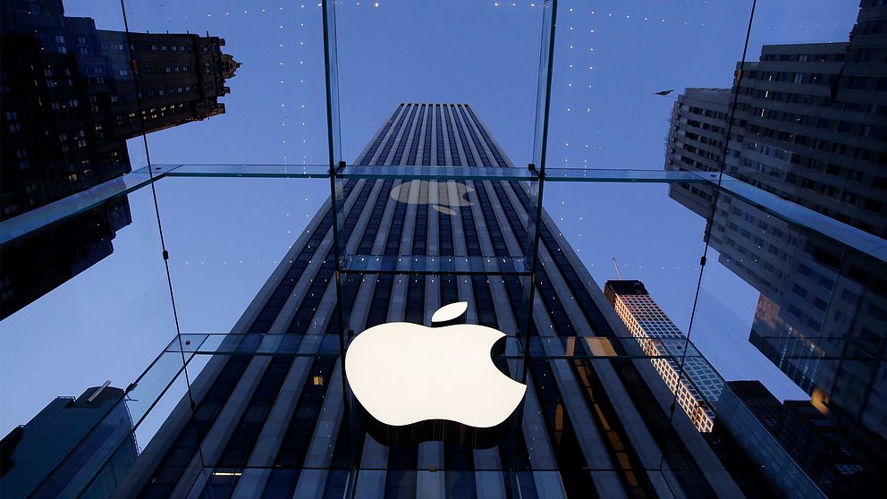 Bild på en vit lysande apple-logga hänger från ett glastak i en av Apples flagshipstore i New York.