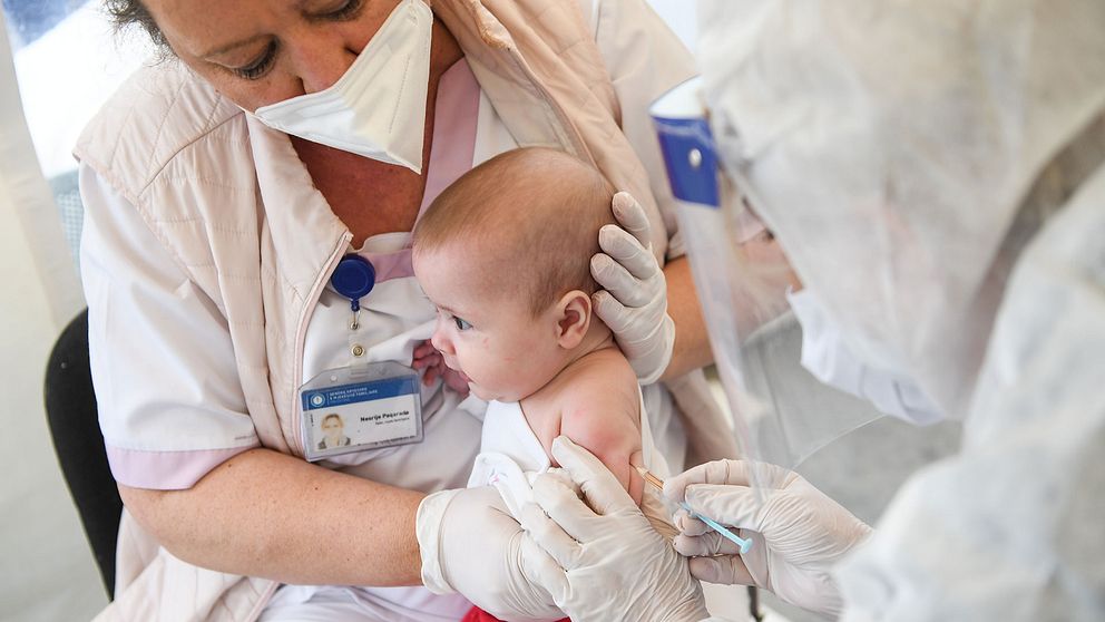 Sjuksköterskor i Kosovo vaccinerar ett barn under covid-19 pandemin.