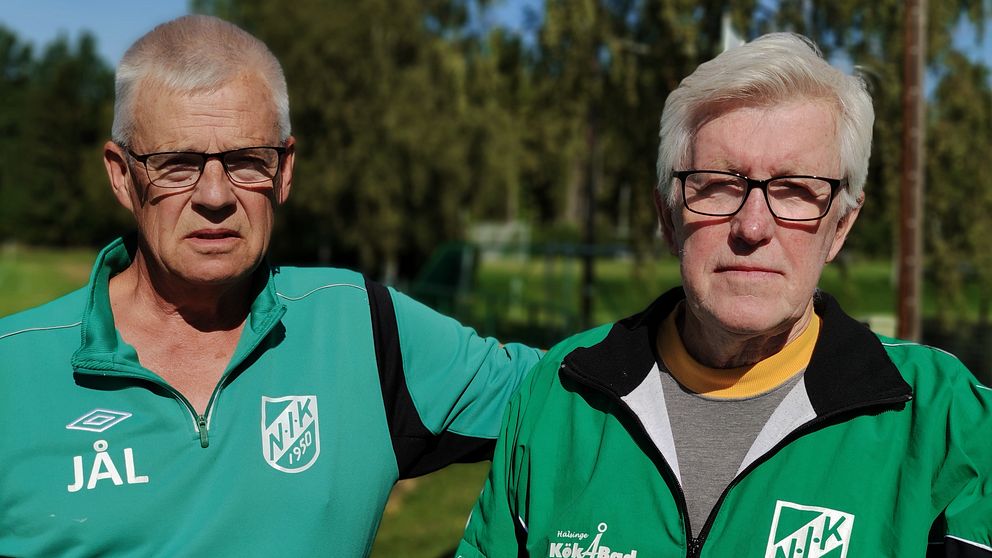 Jan-Åke Larsson och Åke Nilsson iklädda gröna NIK-tröjor. Båda har svarta glasögon på sig.