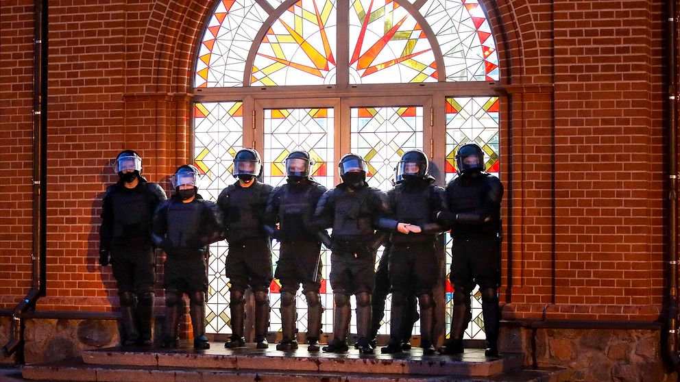 Säkerhetsstyrkor blockerar entrén till en kyrka under protester på Självständighetstorget i Minsk.