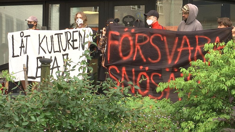 Maskerade demonstranter håller banderoller med texterna ”Låt kulturen leva” och ”Försvara Snösätra”.