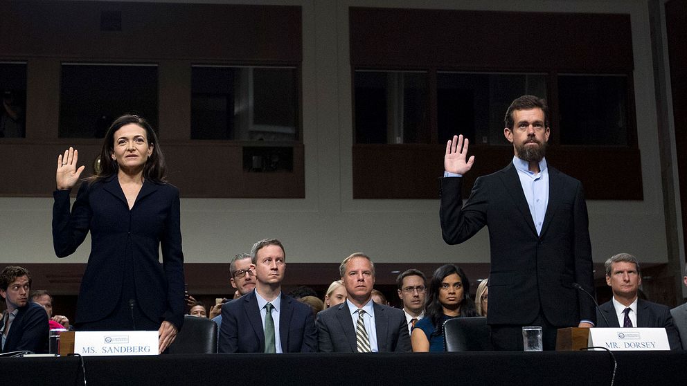 Facebooks operative chef Sheryl Sandberg och Twitters vd Jack Dorsey när de svär sanningsed inför utfrågning av amerikanska senatens underrättelseutskott.