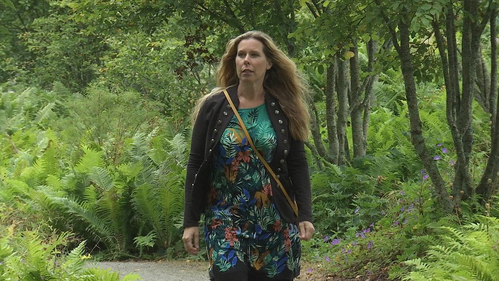 Carola Jansson gåendes på en stig i en lummig park.