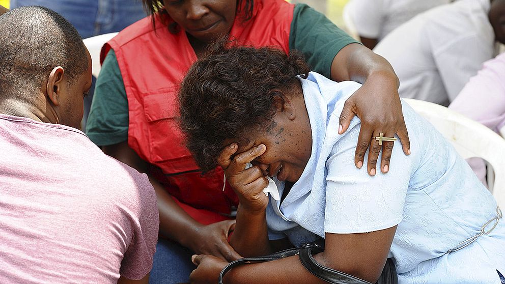 Anhöriga till offer i skolmassakern tas om hand av sjukvårdare i Nairobi.