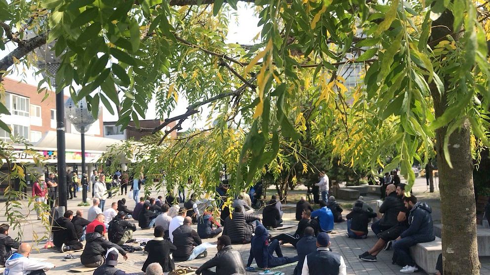 Ett 30-tal män har vid lunchtid samlats för fredagsbön nära den plats där en koran brändes på fredagsmorgonen.