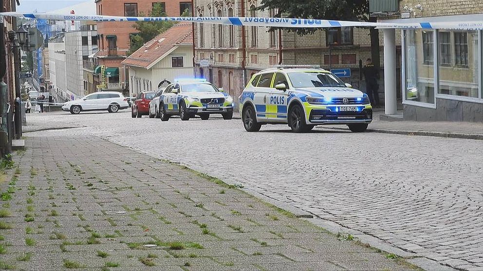 Två polisbilar med blåljus parkerade på en gata i Borås.