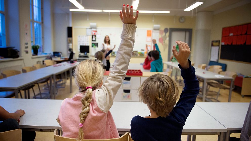 Elever räcker upp handen på en skola. Bild från 2014.