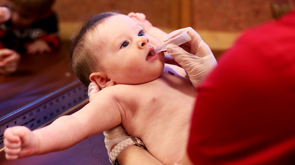 Debatten om vaccinering rasar på flera håll i världen, bland annat i delstaten Oregon i USA där det här barnet får ett vacccin oralt.