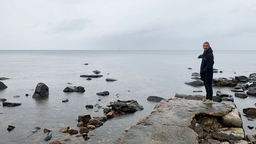 Zafer Taylor står på resterna av en gammal brygga i Mölle.