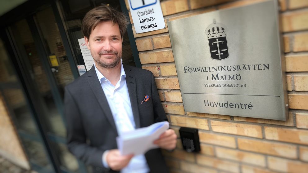 rådman Mattias Steen framför skylt vid förvaltningsrätten