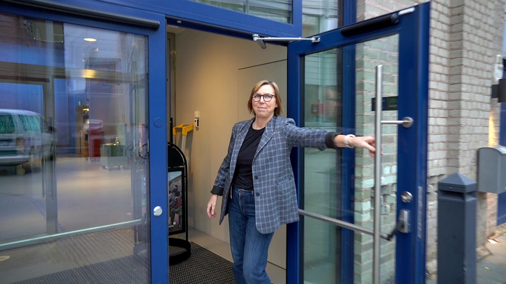 Kvinna håller upp dörren till nya curiosum i Umeå