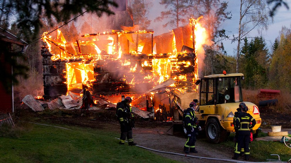 eldsvåda i hus på skogstomt, nästan nedbrunnet, räddningspersonal i förgrundne