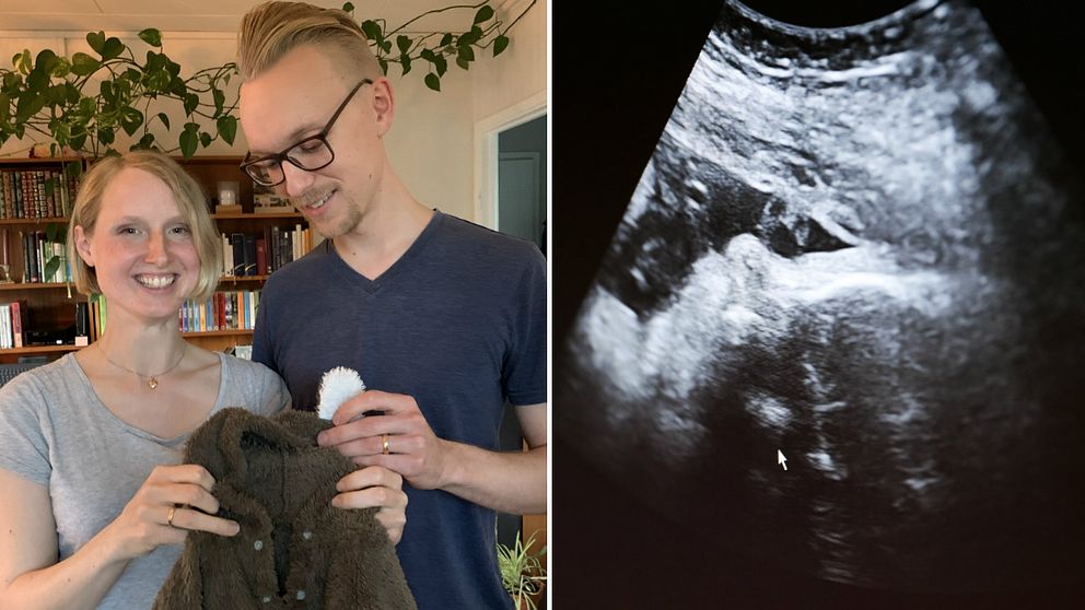 Blond kvinna och man med glasögon håller upp en lite tröja för baby. Bredvid är en svartbild foto på ett ultraljud.
