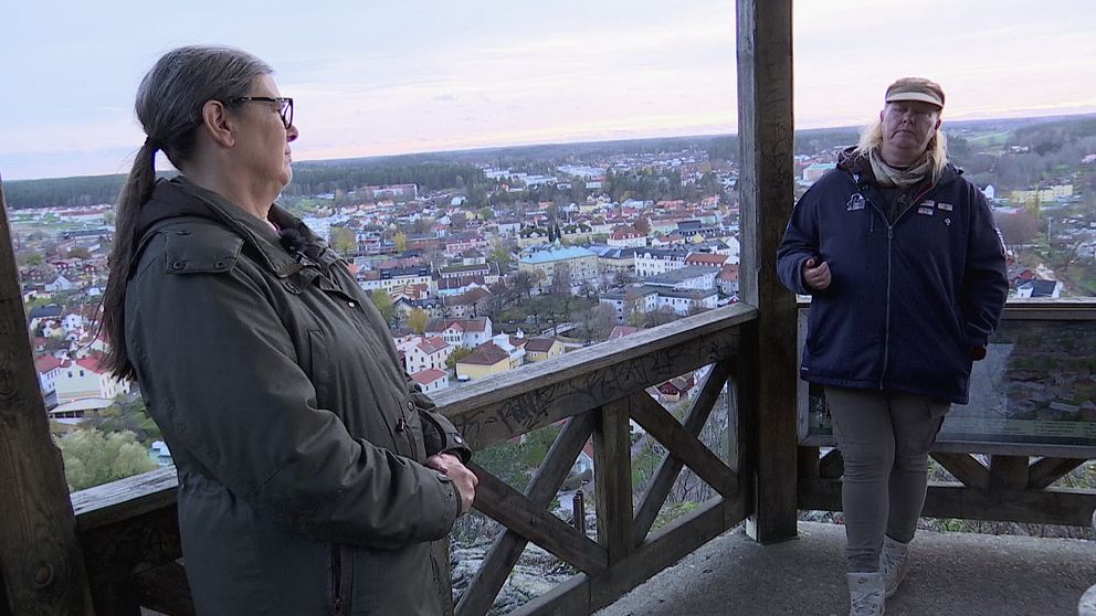 Boel Holgersson och Åsa Dahlin står lutade mot räcket vid utkikstornet högst uppe på Ramunderberget i Söderköping.