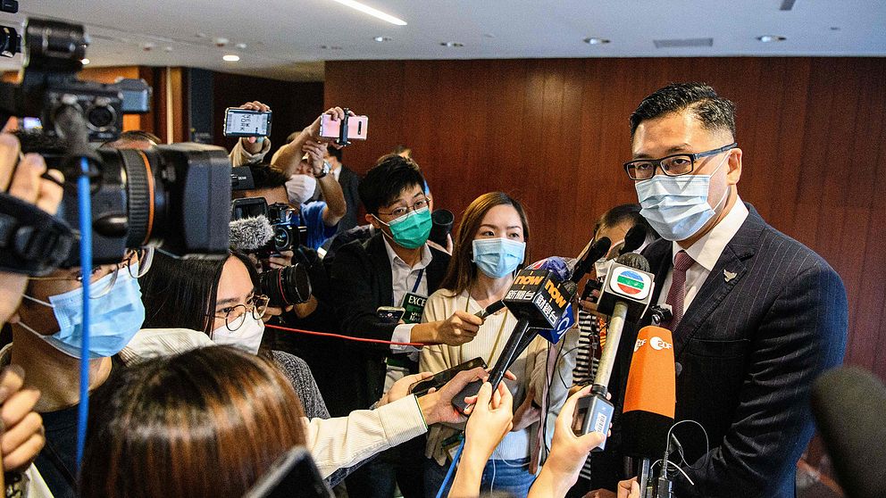 Parlamentsledamoten Lam Cheuk-ting svarar på frågor från reportrar med mikrofoner i inomhusmiljö, alla införda munskydd.