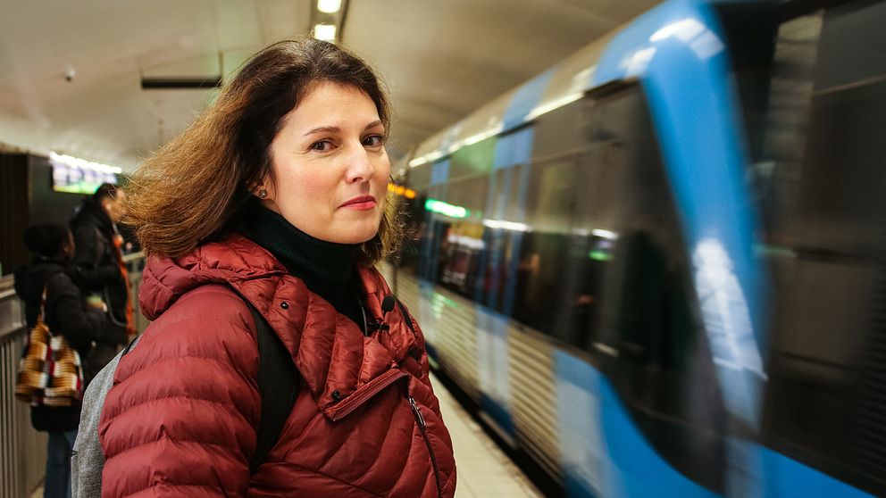 Kvinna framför åkande tunnelbanetåg