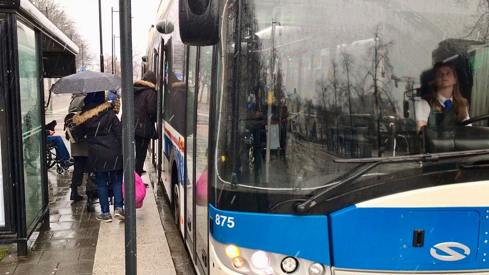 Resenärer går in och ur bussen genom bakdörrarna.