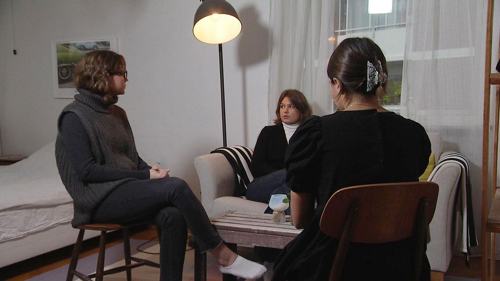 Alicia Hernqvist, Hanna Lindvall och Angele Pesce sitter i ett vardagsrum och pratar.