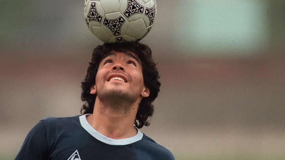 Fotbollsspelaren Diego Maradona balanserar en boll på huvudet, år 1986.