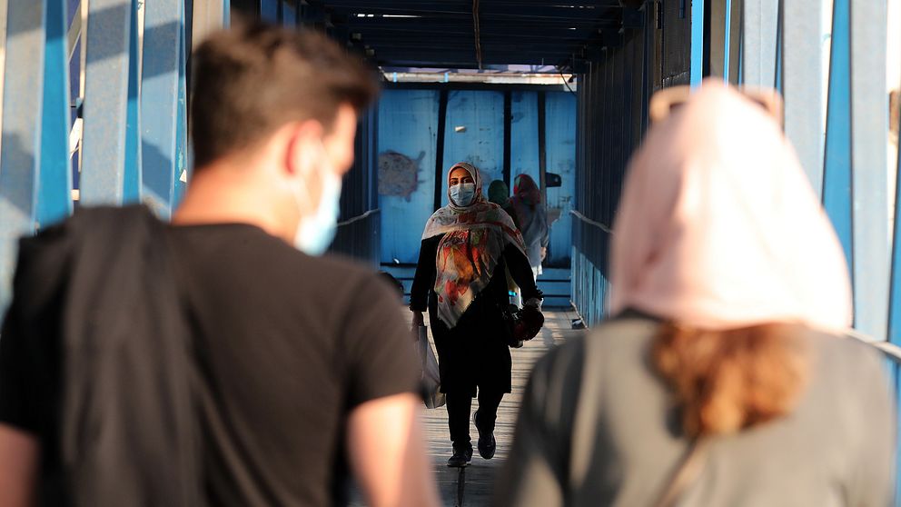 Bild på människor i Teheran under coronapandemin bärandes munskydd.