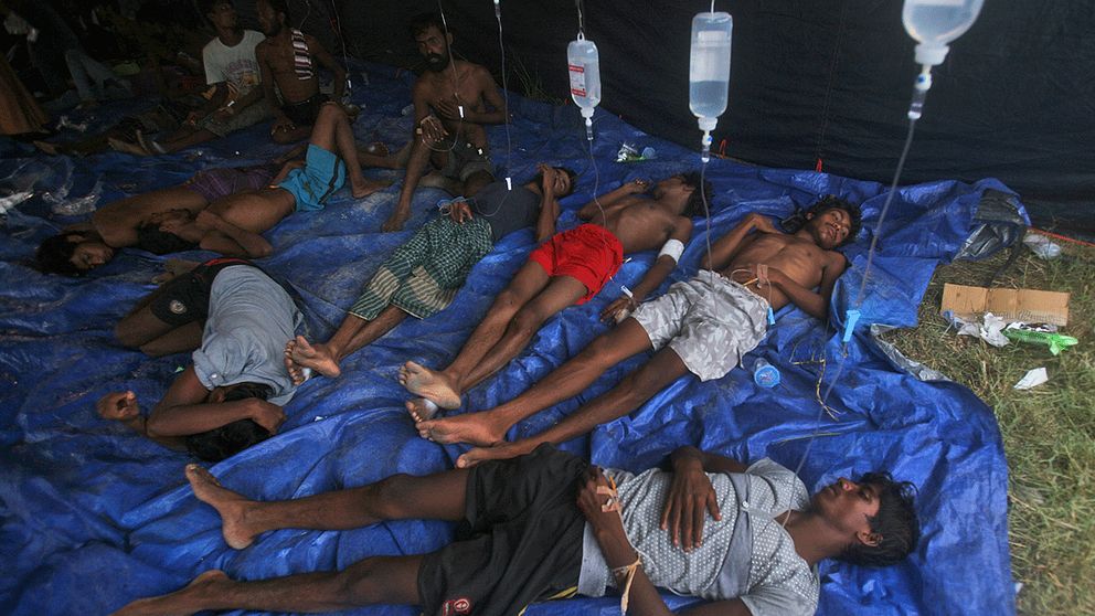 Överlevande behandlas med dropp sedan de räddats från ett sjunkande migrantfartyg utanför Acehprovinsen i Indonesien.