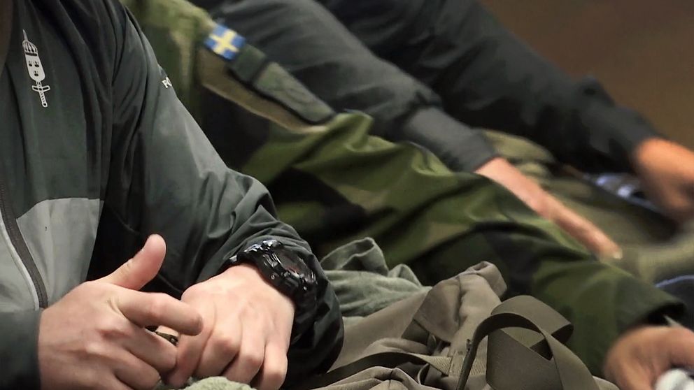 Händer tillhörande värnpliktig som packar en väska