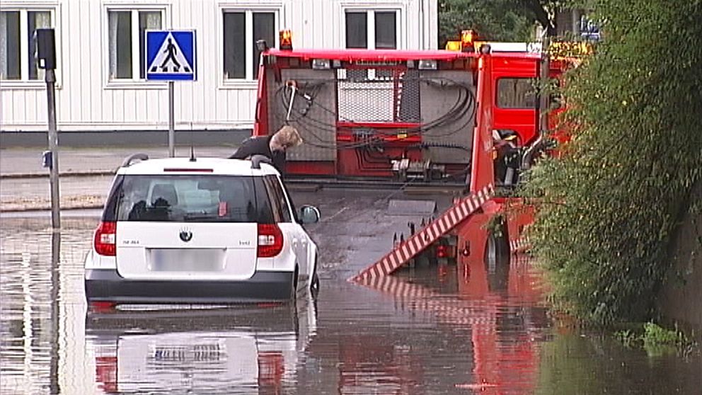 bil bärgas på översvämmad gata