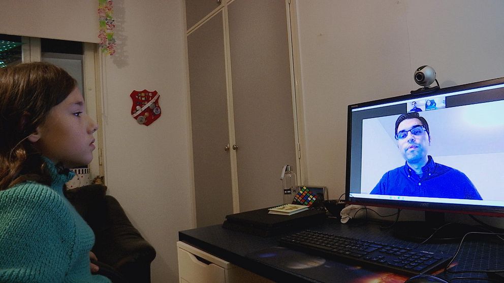 Hampus sitter i sitt rum och tittar på datorn. På skärmen syns Edris som pratar med honom.
