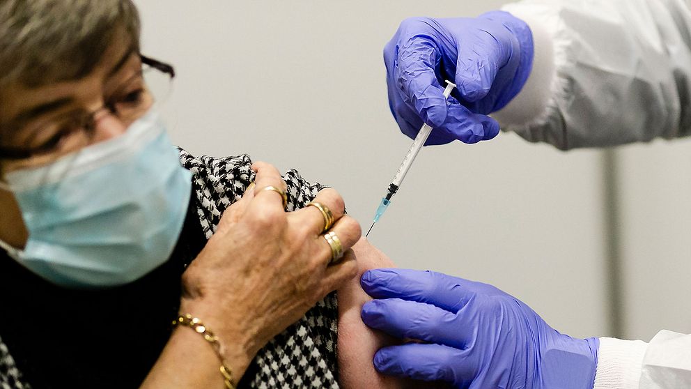 En kvinna får vaccin mot coronaviruset.