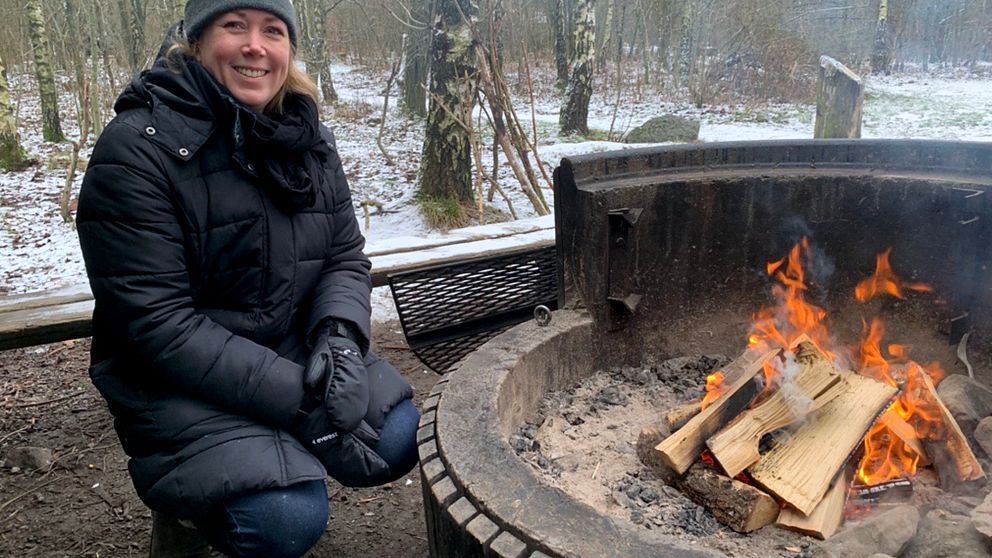 Emelie Nilsson sitter vid en eld