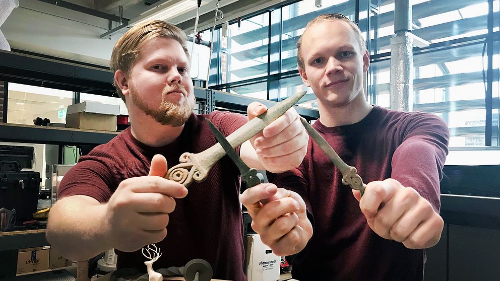 Joakim Wahlberg och Tim Malmgren håller upp knivar som de tillverkat i sin 3D-skrivare, som skapat exakta kopior av fynd från bronsåldern