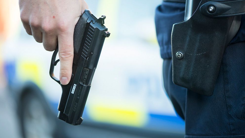 Hand som håller i en pistol, polisens tjänstevapen.