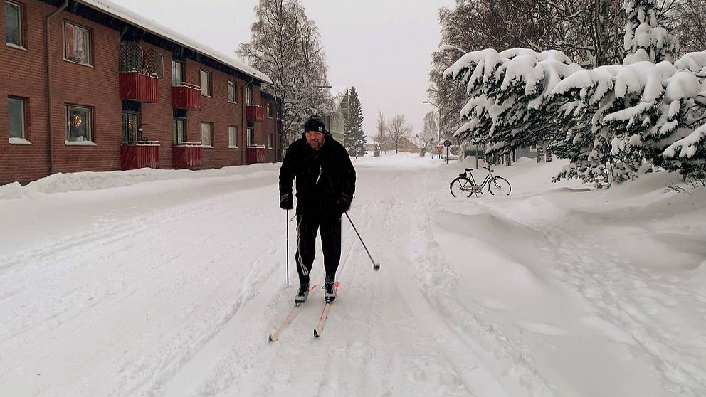 En mörkt klädd man åker skidor på en gata i Östersund