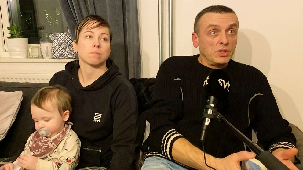En kvinna, en man och ett litet barn sitter i en soffa i en lägenhet och blir intervjuade.