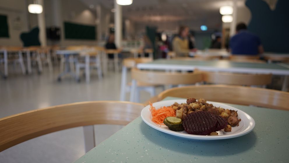 En tallrik med pytt i panna upplagd på bord i skolmatsal