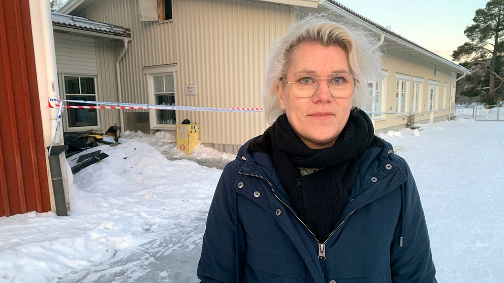 Skolchef Kristina Rastbäck står framför den del av skolan som brann i natt.