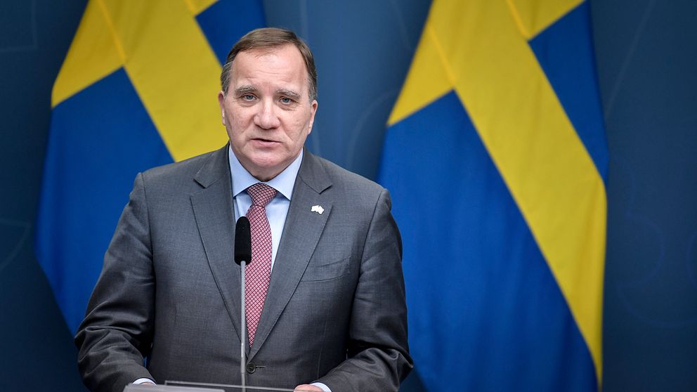 Bilden visar statsminister Stefan Löfven (S) framför två svenska flaggor.