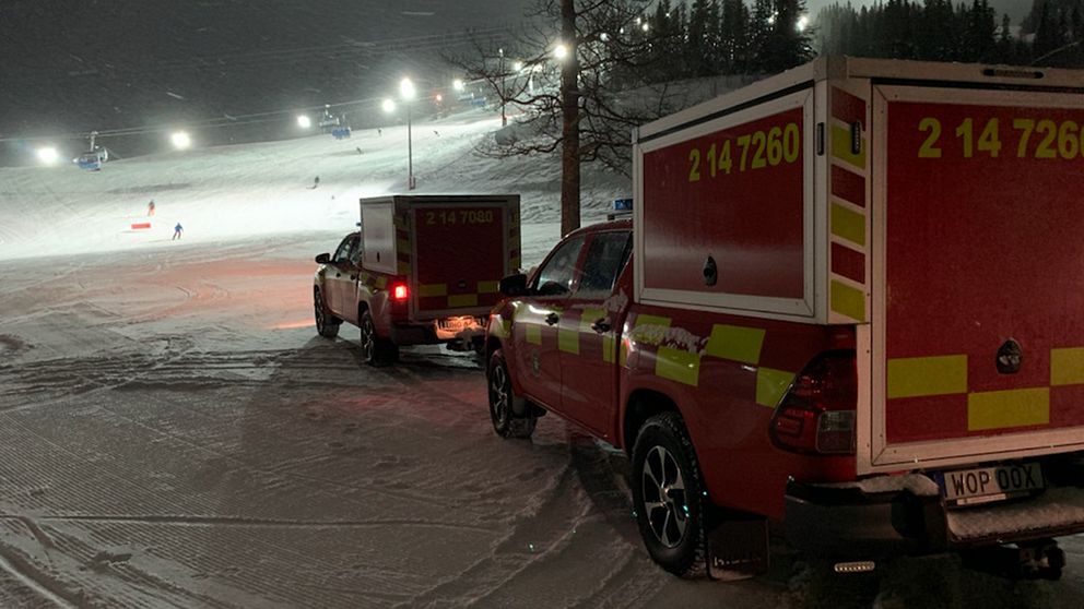 Två bilar från räddningstjänsten står vid foten av en slalombacke.