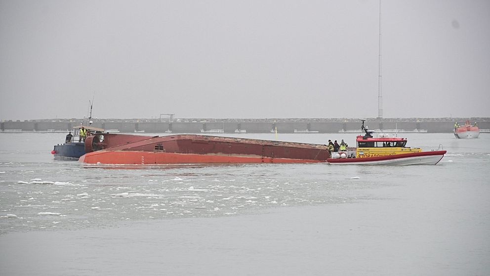 kantrad arbetsbåt vid sidan om en sjöräddningskryssare i Trelleborgs hamn