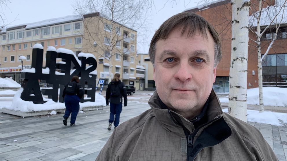 Socialdemokratiskt kommunalråd i Skellefteå, Lorents Burman, kollar in i kameralinsen. I bakgrunden syns baksidan av Skellefteå-bokstäverna på torget i centrum.