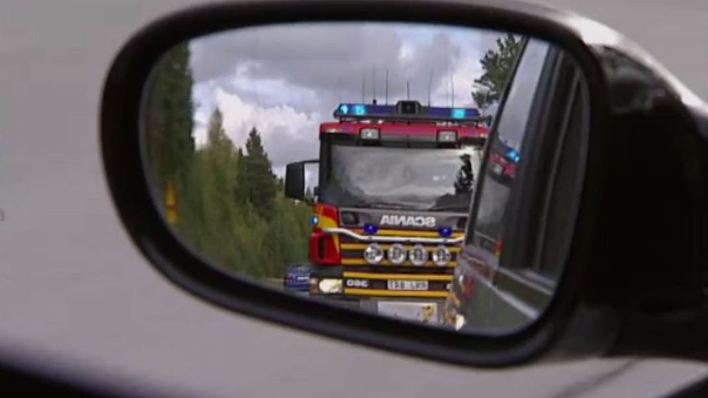 En brandbil syns genom en sidobackspegel.